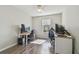 Bedroom with wood flooring features two work stations, natural light, and a ceiling fan at 4528 Winding River Way, Land O Lakes, FL 34639