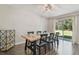 Bright dining room with wood table, seating for six, and sliding glass doors to backyard at 4528 Winding River Way, Land O Lakes, FL 34639