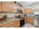 Modern kitchen features granite counters, stainless appliances, and wood cabinetry at 4528 Winding River Way, Land O Lakes, FL 34639