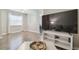 Bright living room with wood floors, and large television over white console table at 4528 Winding River Way, Land O Lakes, FL 34639