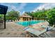Community pool with lounge chairs, shade, and tropical landscaping for relaxing days at 4528 Winding River Way, Land O Lakes, FL 34639