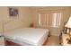 Bright bedroom featuring a cream bed frame, a window with blinds and neutral colored walls at 4744 Azalea Dr # 203B, New Port Richey, FL 34652