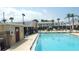 Bright community pool area with adjacent buildings, landscaping, and lounge chairs at 4744 Azalea Dr # 203B, New Port Richey, FL 34652