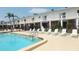 Sparkling community pool with comfortable lounge chairs and shaded umbrellas for relaxation at 4744 Azalea Dr # 203B, New Port Richey, FL 34652