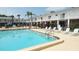 Community pool surrounded by lounge chairs and lush landscaping, ideal for relaxation and leisure at 4744 Azalea Dr # 203B, New Port Richey, FL 34652