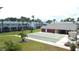 Community shuffleboard court and clubhouse surrounded by lush landscaping at 4744 Azalea Dr # 203B, New Port Richey, FL 34652