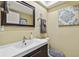Cozy half bathroom with tiled floors, a mirror, a sink, and decorated with artwork on the wall at 511 Sandy Hook Rd, Treasure Island, FL 33706