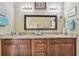 Bathroom has dual sinks, granite countertops and dark wood cabinets, and neutral colors at 511 Sandy Hook Rd, Treasure Island, FL 33706
