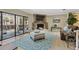 Spacious living room with stone fireplace, balcony access, and stylish furniture at 511 Sandy Hook Rd, Treasure Island, FL 33706
