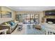 Bright living room featuring a stone fireplace, comfortable seating, and sliding glass doors to a balcony at 511 Sandy Hook Rd, Treasure Island, FL 33706