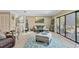 Open-concept living area with balcony access, fireplace, neutral tones, and modern decor elements at 511 Sandy Hook Rd, Treasure Island, FL 33706