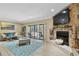 Cozy living area with a stone fireplace, opening to balcony and decorated with a coastal vibe at 511 Sandy Hook Rd, Treasure Island, FL 33706