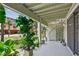 Relaxing covered patio features a spiral staircase and verdant landscaping, perfect for outdoor living at 511 Sandy Hook Rd, Treasure Island, FL 33706