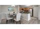 Dining area with a black round table, white chairs, and an adjacent kitchen with stainless steel appliances and wood cabinets at 5582 Baywater Dr, Tampa, FL 33615