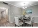 Dining area featuring modern decor with a round table, upholstered chairs, wainscoting, and a sailboat-themed art piece at 5582 Baywater Dr, Tampa, FL 33615