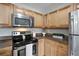 Kitchen showcasing stainless steel appliances, wood cabinets, and granite countertops with natural light at 5582 Baywater Dr, Tampa, FL 33615