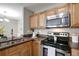 Kitchen showcasing stainless steel appliances, wood cabinets, and granite countertops open to the dining area at 5582 Baywater Dr, Tampa, FL 33615