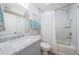 Bathroom featuring a vanity with marble top, shower over tub with white tile surround, and modern fixtures at 6151 Bahia Del Mar Blvd # 126, St Petersburg, FL 33715