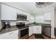 Modern kitchen featuring stainless steel appliances, granite countertops, and white cabinetry at 6151 Bahia Del Mar Blvd # 126, St Petersburg, FL 33715