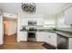 Modern kitchen featuring stainless steel appliances, granite countertops, white cabinets and wood flooring at 6151 Bahia Del Mar Blvd # 126, St Petersburg, FL 33715