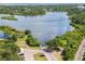Scenic aerial view of a tranquil lake with lush green surroundings and a boat launch and parking area nearby at 670 Wooddell Dr, Safety Harbor, FL 34695