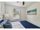 Comfortable bedroom with white walls, blue accents, and natural light from the window at 670 Wooddell Dr, Safety Harbor, FL 34695