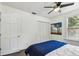 Bright bedroom with ceiling fan, closet, neutral paint, and view of outdoor greenery at 670 Wooddell Dr, Safety Harbor, FL 34695