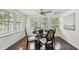 Bright dining area features hardwood floors, modern ceiling fan, and plenty of natural light from the surrounding windows at 670 Wooddell Dr, Safety Harbor, FL 34695