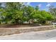 This house has beautiful mature trees in the front yard, white siding, and an orange front door at 670 Wooddell Dr, Safety Harbor, FL 34695