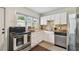 Well-lit kitchen featuring white cabinets, stainless steel appliances, and a charming backsplash for a modern feel at 670 Wooddell Dr, Safety Harbor, FL 34695