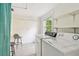 Laundry room includes washer, dryer, storage shelving and adjacent natural light source at 670 Wooddell Dr, Safety Harbor, FL 34695