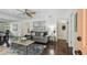 Inviting living room features dark hardwood floors, a sectional couch, and natural light filtering through the windows at 670 Wooddell Dr, Safety Harbor, FL 34695