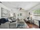 Bright living room with hardwood floors, a ceiling fan, a comfortable gray couch, and stylish decor throughout at 670 Wooddell Dr, Safety Harbor, FL 34695