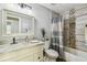 Well-lit bathroom featuring a decorative mirror, marble countertop, and tiled shower at 7004 Westminster St, Tampa, FL 33635