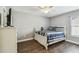 Bright bedroom with wood-look floors, ceiling fan, and a cozy bed with striped bedding at 7004 Westminster St, Tampa, FL 33635