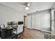 Bedroom space with wood-look floors, ceiling fan, and an adjacent work space for remote work at 7004 Westminster St, Tampa, FL 33635