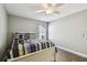 Bright bedroom with wood-look floors, ceiling fan, and a cozy bed with striped bedding at 7004 Westminster St, Tampa, FL 33635