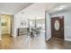 View of the dining area and entrance featuring stylish furnishings, wood-look tile, and a charming front door at 7004 Westminster St, Tampa, FL 33635