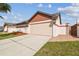Beautiful house featuring a two-car garage, neutral stucco exterior and well manicured lawn and mulched flower beds at 7004 Westminster St, Tampa, FL 33635