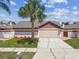 Attractive single-story home featuring a lush lawn and a freshly sealed driveway, with mature trees at 7004 Westminster St, Tampa, FL 33635
