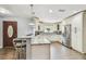White kitchen featuring an island with barstool seating and stainless-steel appliances at 7004 Westminster St, Tampa, FL 33635