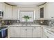Well-lit kitchen featuring stylish countertops, backsplash, stainless steel appliances and ample cabinet storage at 7004 Westminster St, Tampa, FL 33635