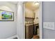 Compact laundry room featuring modern washer and dryer units, upper cabinets, and neutral-toned walls at 7004 Westminster St, Tampa, FL 33635