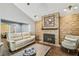 Cozy living room featuring a brick fireplace, vaulted ceiling, and stylish furnishings on top of wood-look tile flooring at 7004 Westminster St, Tampa, FL 33635