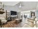 Open-concept living room with a ceiling fan, media center, and seamless flow into the dining area with wood-look tile at 7004 Westminster St, Tampa, FL 33635