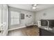 Home office featuring wood-look floors, window with blinds, modern desk setup, and neutral paint at 7004 Westminster St, Tampa, FL 33635