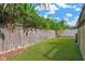 Well-maintained backyard with lush green grass and a tall wooden privacy fence at 7208 S Juanita St, Tampa, FL 33616