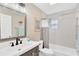 Neutral bathroom with updated vanity, a shower-tub combo and modern fixtures at 7208 S Juanita St, Tampa, FL 33616