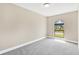 Bright bedroom with neutral walls, plush carpeting, and natural light from a charming arched window at 7208 S Juanita St, Tampa, FL 33616