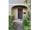 Charming front entrance with secure iron gate and lush landscaping, leading to a welcoming home at 7601 W Deleon Ct, Tampa, FL 33615